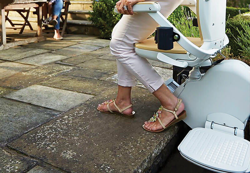 Close-up of an outdoor stairlift seat fitted to brick garden steps